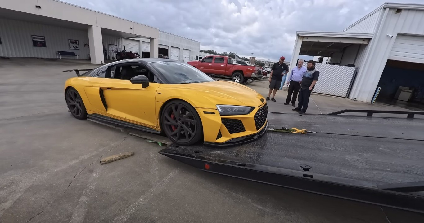 Emergency towing service carefully loading yellow sports car on flatbed in Hollister, CA